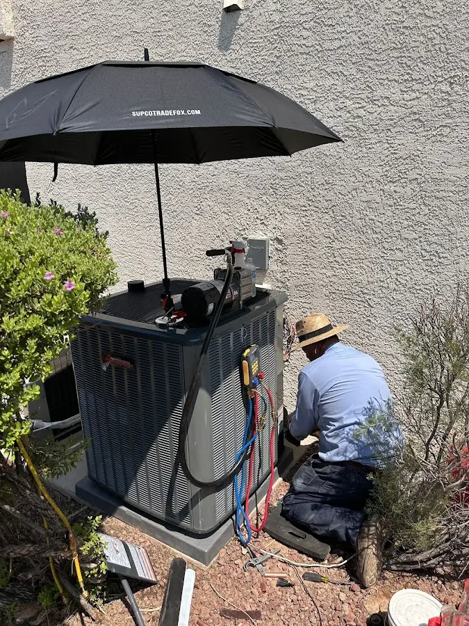 HVAC technician performing outdoor AC maintenance in North Lakes