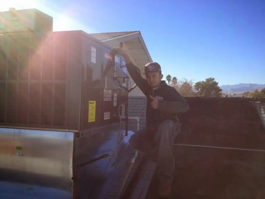 HVAC technician performing AC Tune-Up on a rooftop unit in North Lakes